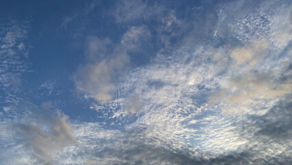 Clouds between innocent white and gloomy floating side by side in the sky on a day when the sky is...