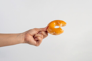 Glazed donut in hand on white background