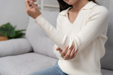 woman holding on elbow and while and suffer from unbearable pain health and problems, chronic...