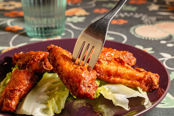 Delicious Fried Chicken Wings Served with Fresh Lettuce on a Stylish Plate