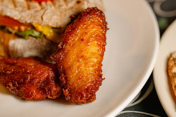 Delicious Fried Chicken Wings and Sandwich on a White Plate