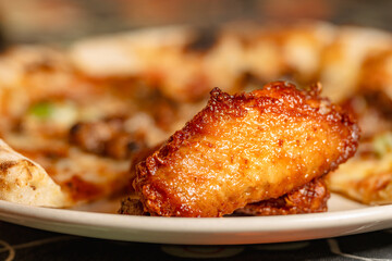 Delicious Fried Chicken Wings and Pizza Served on a Plate