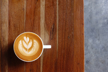  a cup of latte art coffee on wooden background                                                                                                                                                         