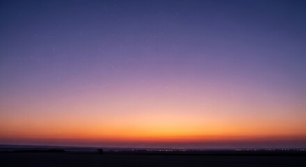 Fototapeta premium Colorful sunset with stars illuminating the horizon over the desert landscape creating a serene
