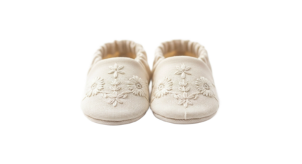 Pair of creamcolored fabric baby shoes with delicate monochromatic floral embroidery. PNG Transparent