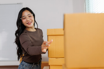 Smiling female entrepreneur arranging cardboard boxes in warehouse