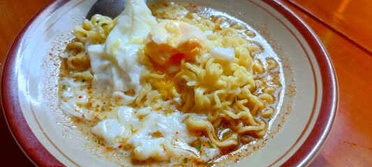 Photo of boiled noodles with half-cooked egg.
