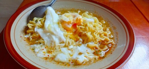 Photo of boiled noodles with half-cooked egg.