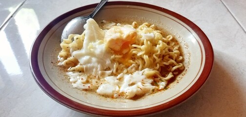 Photo of boiled noodles with half-cooked egg.