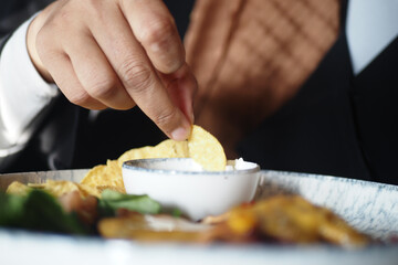 Enjoying snacks with dip at a dining setting