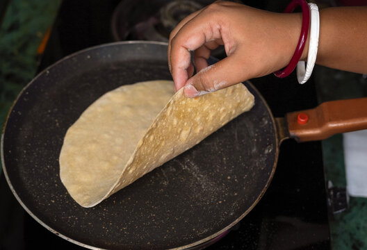 Indian chapati or fulka or gehu roti with wheat grains in background. It's a healthy fiber rich traditional North and South Indian food, selective focus