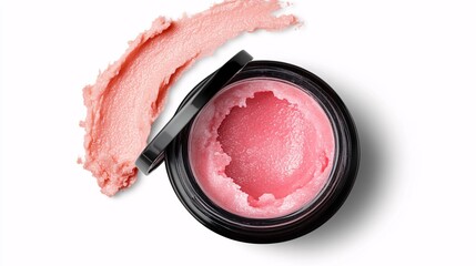 Pink lip scrub in black jar with smear on white background, top view