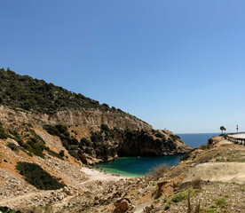 Beautiful secluded beach with clear water and rocky cliffs during sunny day