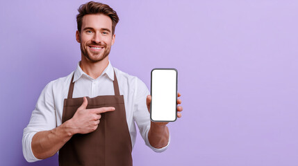 Smiling male barista pointing at a smartphone with a blank screen. Perfect for app mockups, digital menus, cafe promotions, or mobile ordering concepts in a modern coffee shop.
