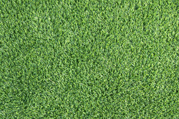 close-up of a lush, green artificial turf. The synthetic blades of grass are perfectly aligned and...