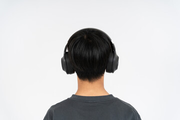 The back view of a boy listening to music with headphones