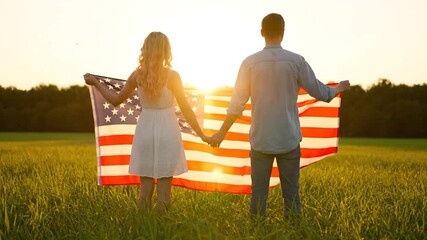 Man and woman raising the US flag over a field of wheat at sunset
- Powered by Adobe