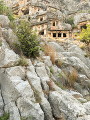 Ruins of ancient structures nestled among rocky cliffs at sunset in a remote location