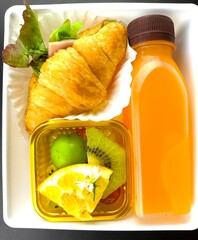 Croissant with orange juice in plastic box, indoor Chiangmai Thailand.