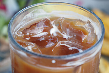 Iced coffee with ice cubes served on a sunny day