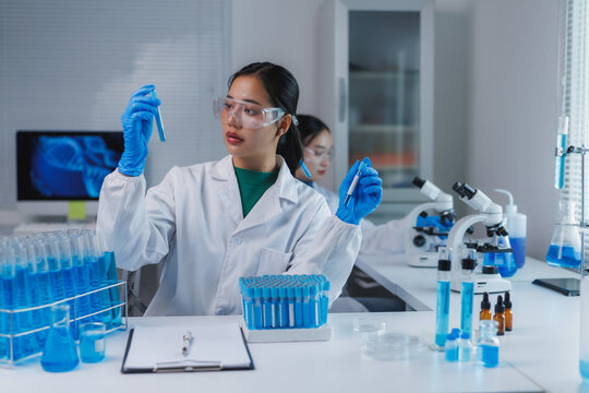 Scientist analyzing blue liquid in test tube in laboratory