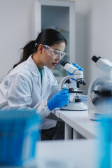 Scientist using microscope doing research in laboratory