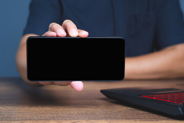 Close-up of hand showing blank phone screen in horizontal mode for mockup, UI, or digital template use.