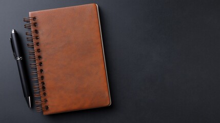 Brown Leather Spiral Notebook with Black Pen – Top-Down View on Matte Black Background