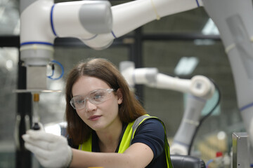 Fototapeta premium Caucasian engineer woman working on AI technology in robotics electronics engineering laboratory. University students' research project is programming robot machine with intelligent mechanical control