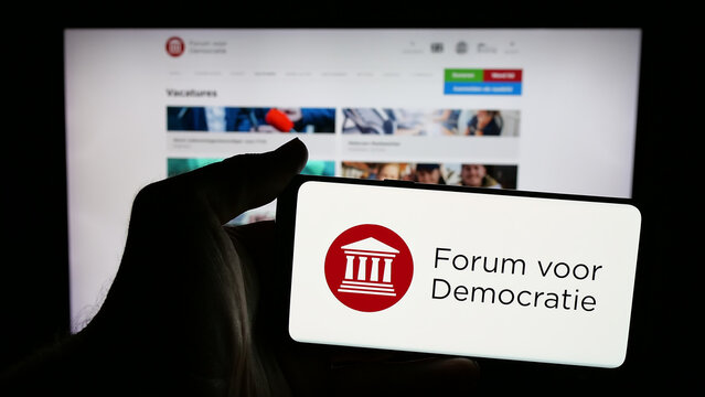 Stuttgart, Germany - 07-10-2025: Person holding mobile phone with logo of Dutch party Forum voor Democratie (FvD) on screen in front of web page. Focus on phone display.