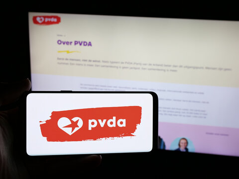 Stuttgart, Germany - 07-10-2025: Person holding smartphone with logo of Partij van de Arbeid van Belgie (PVDA) on screen in front of website. Focus on phone display.