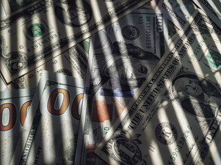 The shadow of the blinds resembles the grid on dollar bills. The concept of prison, punishment for...