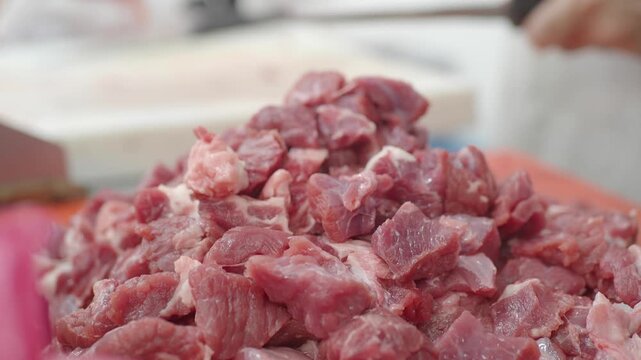 Meat preparation at a local market in a bustling environment