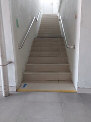 Indoor Staircase with Handrails and Safety Arrow in Building
