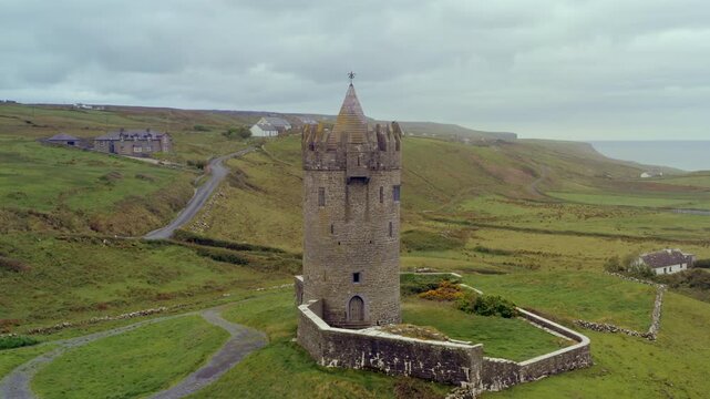 Slow aerial orbit of Doonagore Castle, with the cliffs of moher on Background