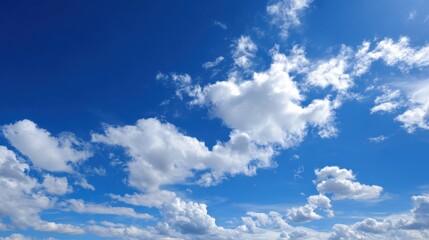 A clear blue sky stretches overhead, dotted with fluffy white clouds. The scene suggests a bright sunny day, ideal for outdoor activities or relaxation.