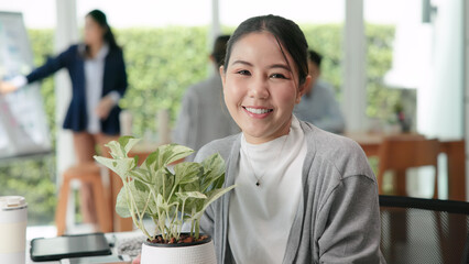 The way forward save the planet earth Gen Z female asia people go green net zero waste ESG office desk. Portrait headshot face young adult woman asian SDGs auditor work look at camera smile happy.