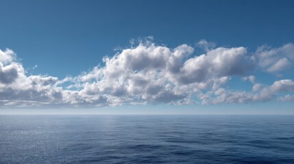A serene ocean view features calm waters reflecting fluffy clouds against a bright blue sky. This peaceful scene captures the tranquility of nature in the morning light.
