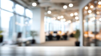 A spacious office interior features large windows allowing natural light to pour in. The blurred background shows workstations and warm lighting, creating an inviting atmosphere for productivity.