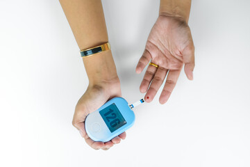 Woman's hands checking diabetes and hyperglycemia with digital blood sugar meter. Healthcare and...