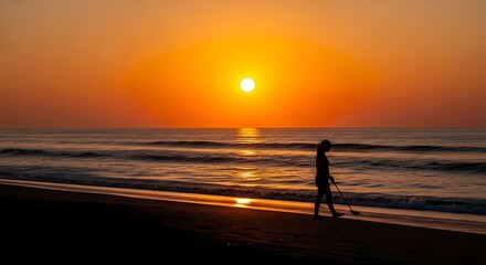 Fototapeta premium Person Metal Detecting on Beach at Sunset with Orange Sky and Ocean Waves