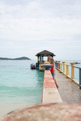 Tourists enjoying beautiful seascape from a pier in perhentian kecil island, malaysia