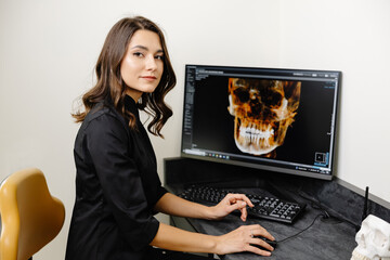 The dentist shows the patient his x-ray of the jaw. Panoramic shot of teeth on the screen at the...