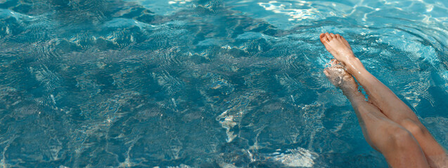 A girl's feet in a blue pool. Epilation of legs, varicose veins. Rest, relaxation on the beach, at...