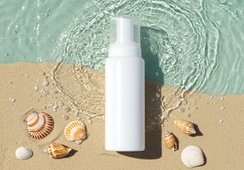 cosmetic skincare bottle placed on sand beach with seashells