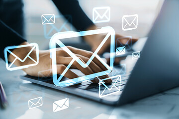 Hands typing on laptop with floating digital email icons symbolizing online communication and...