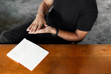 Man Sitting at Desk with Blank Notebook Mockup, Hands in Gesture