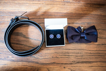 Wedding accessories including a belt, cufflinks, and bow tie