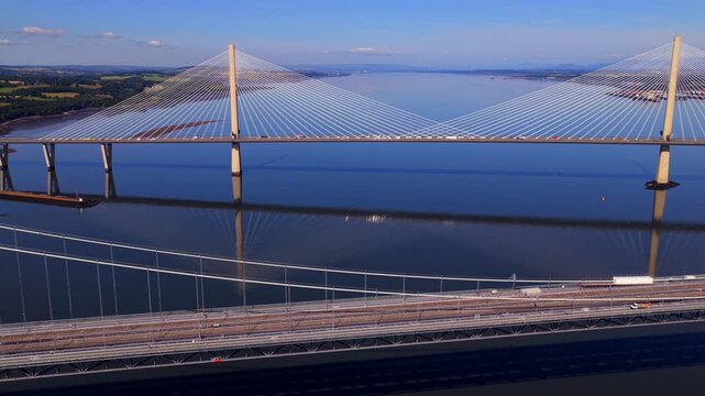 Aerial video of the Forth road Bridge in Edinburgh Scotland with Queensferry crossing Bridge on the background. 