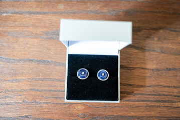 Elegant wedding cufflinks displayed in a box on wooden surface